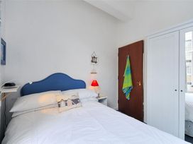 A bedroom with a blue bed and bedside table at 1 The Old Posthouse in Lyme Regis