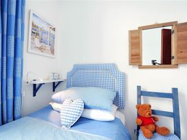 A bedroom with blue decor and a teddy bear at 1 The Old Posthouse in Lyme Regis