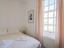 A bedroom with a bed and a lamp at 1 The Old Posthouse in Lyme Regis