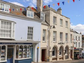 A street view with storefronts and bunting at 1 The Old Posthouse Lyme Regis