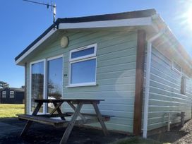 A cabin with a table and bench outside at Embury