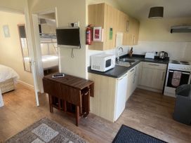 A kitchen area with appliances and a bedroom view at Embury 