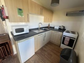 A kitchen with appliances including a refrigerator, microwave, and oven at Embury