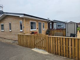 A wooden house with a fence and a shed at 38A Bridlington