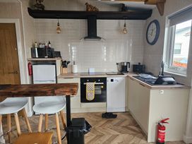 A kitchen with appliances and seating area at 38A in Bridlington
