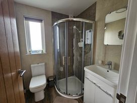 A bathroom with a shower, sink, and toilet at 38A Bridlington
