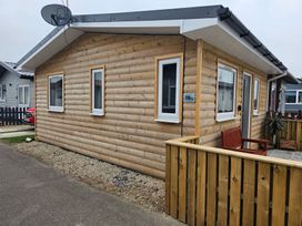 A wooden house with a satellite dish and a fence at 38A Bridlington
