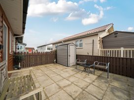 An outdoor patio area with a shed and seating at 38A in Bridlington