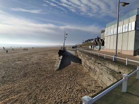 A beach with people walking along the shore at 311 Bridlington