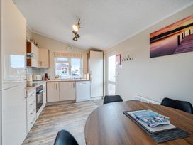 A kitchen with cabinets and a dining table at 311 Bridlington