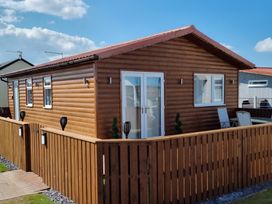 A wooden cabin with a fence and door at 50 Bridlington
