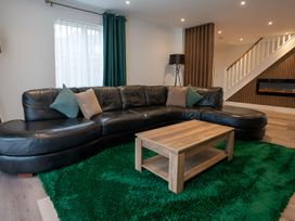 A living room with a black sofa and wooden coffee table at The Galloway in Morpeth