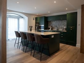 A kitchen with an island and bar stools at The Galloway in Morpeth