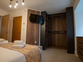 A bedroom with a bed towels and a wardrobe at The Galloway in Morpeth