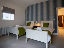 A bedroom with two beds and a nightstand at The Galloway in Morpeth