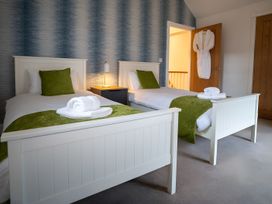 A bedroom with two beds, a nightstand, and a robe at The Galloway in Morpeth