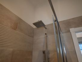 A shower with a glass door and wall tiles at The Shearling in Morpeth