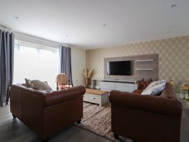 A living room with sofas and a TV at The Newland in Morpeth