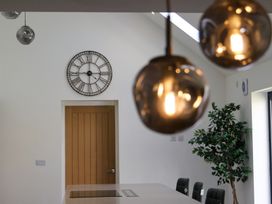 A kitchen with a clock and pendant lights at The Newland in Morpeth