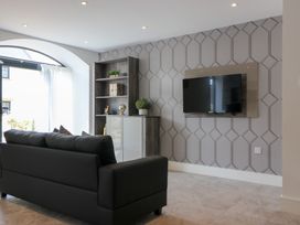 A living room with a sofa and a television on the wall at The Gavel in Morpeth