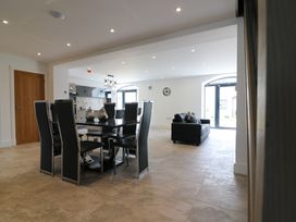 A dining room with a table and chairs adjacent to a living area at The Gavel in Morpeth
