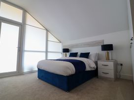 A bedroom with a bed, bedside table, and lamp at The Gavel in Morpeth