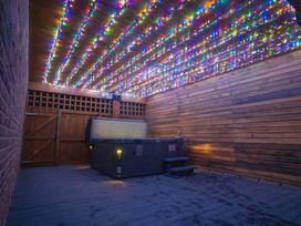 An outdoor area with a hot tub and string lights at The Gavel in Morpeth