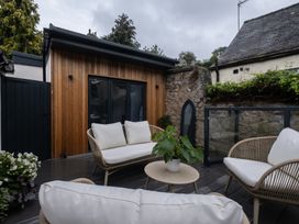 An outdoor seating area with chairs and a table at Honeysuckle Lodge in Knaresborough