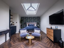 A bedroom with a bed and seating area at Honeysuckle Lodge Knaresborough