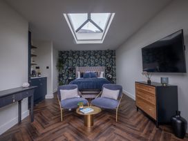 A bedroom with a bed and seating area at Honeysuckle Lodge in Knaresborough
