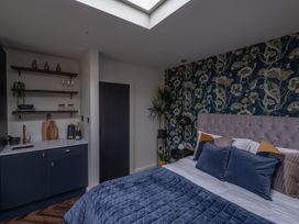 A bedroom with a bed and kitchenette at Honeysuckle Lodge in Knaresborough