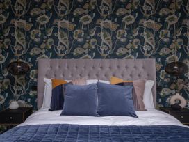 A bedroom featuring a bed with pillows and a decorative wall at Honeysuckle Lodge in Knaresborough
