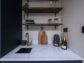 A kitchen with a sink and shelves at Honeysuckle Lodge Knaresborough