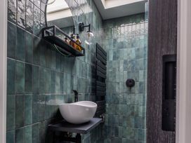A bathroom with a sink and shelf at Honeysuckle Lodge in Knaresborough