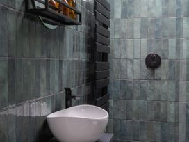 A bathroom with a sink and shelf at Honeysuckle Lodge in Knaresborough