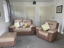 A living room with a sofa and armchair at 19 Carnaby Mews in Bridlington