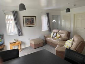 A living room with a sofa and television at 19 Carnaby Mews Bridlington