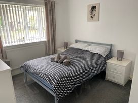 A bedroom with a bed and side tables at 19 Carnaby Mews in Bridlington