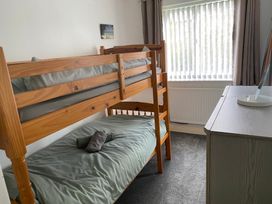 A bedroom with a bunk bed and desk at 19 Carnaby Mews in Bridlington