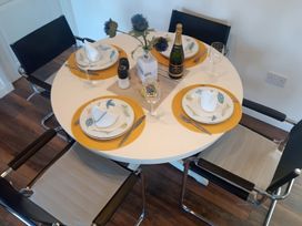 A dining table set with plates and glasses at Gowrie Lodge in Blairgowrie