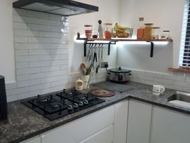 A kitchen with a gas stove and a sink at Gowrie Lodge in Blairgowrie
