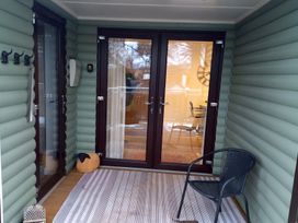 A porch with double doors and a chair at Gowrie Lodge in Blairgowrie