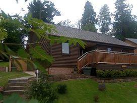 A cabin with deck and landscaped garden at Gowrie Lodge in Blairgowrie