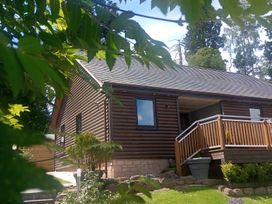 A house with a deck and garden at Gowrie Lodge in Blairgowrie