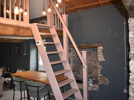 A dining area with stairs and lights at Ty Llaeth in Carmarthen