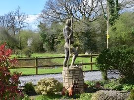 A statue in a garden near a pond at Ty Llaeth in Carmarthen