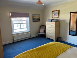 A bedroom with a bed and a dresser at Edal Court in Sheringham