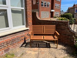 A wooden bench in an outdoor area at Edal Court in Sheringham