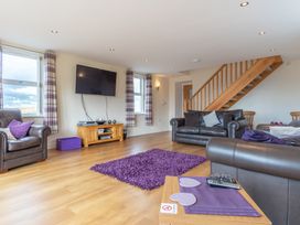 A living room with a television and seating area at Groeslon Uchaf in Caernarfon