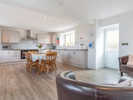 A kitchen with a table and chairs at Groeslon Uchaf in Caernarfon